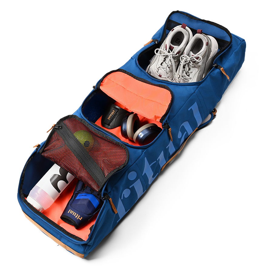 Ritual Mission combo hockey bag blue with compartments containing shoes, headphones, and a bottle, inside view
